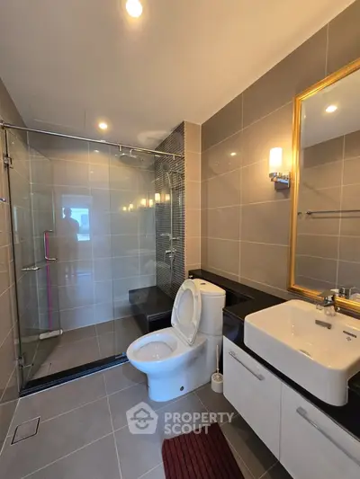 Modern bathroom with glass shower, sleek fixtures, and elegant lighting