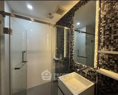 Modern bathroom with sleek glass shower and stylish mosaic tiles
