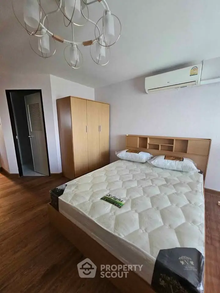Spacious bedroom with modern wooden furniture and air conditioning, perfect for comfort and relaxation.