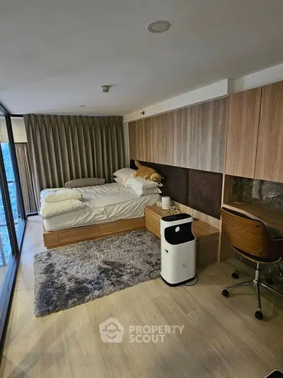 Modern bedroom with stylish decor and large windows offering a stunning city view.