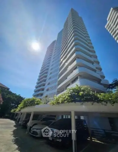 Stunning high-rise building with modern architecture and ample parking space, perfect for urban living.
