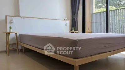 Modern minimalist bedroom with large window and stylish wooden bed frame.