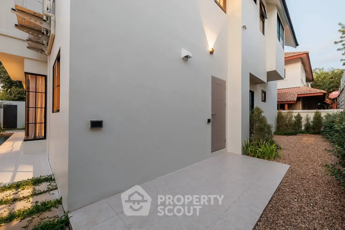 Modern exterior of a contemporary home with clean lines and minimalist design, featuring a small garden area.