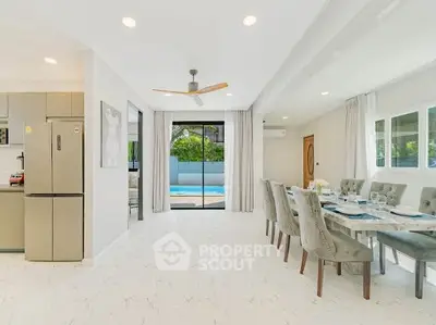 Spacious modern dining area with pool view, elegant decor, and open layout for luxury living.