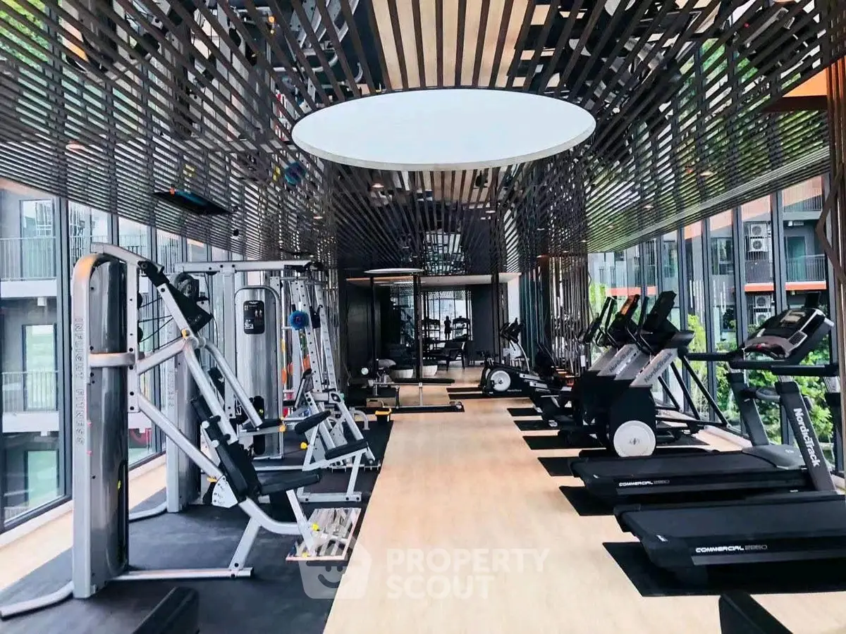 Modern gym with state-of-the-art equipment and sleek design in luxury apartment complex.