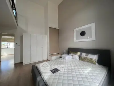 Spacious modern bedroom with high ceiling and elegant decor