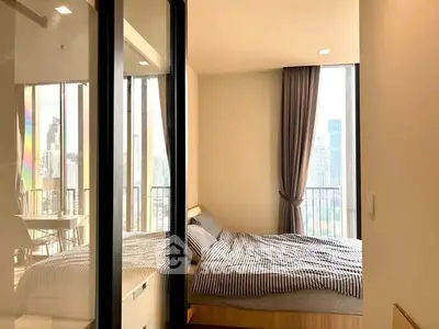 Modern bedroom with city view and balcony access in high-rise apartment