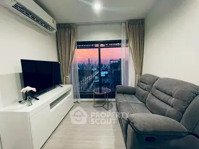 Cozy living room with city view, featuring modern sofa and entertainment unit.