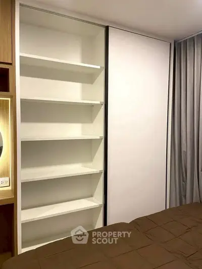 Modern bedroom with built-in shelving and cozy brown bedding