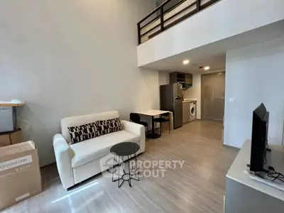 Modern loft-style living room with mezzanine, sleek furniture, and open kitchen layout.