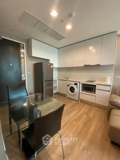 Modern kitchen with sleek appliances and dining area in a stylish apartment.