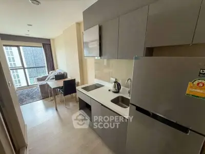 Modern open-layout kitchen with sleek cabinetry and cozy living area in a high-rise apartment.