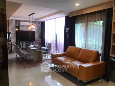 Modern living room with leather sofa, dining table, and large windows with curtains.