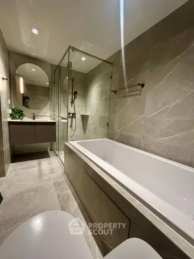 Luxurious modern bathroom with elegant bathtub and glass shower enclosure.