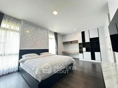 Spacious modern bedroom with elegant decor and ample natural light