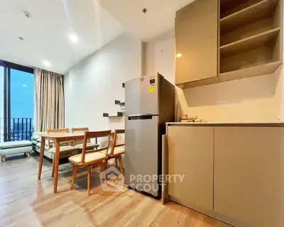 Modern open-layout kitchen and dining area with sleek appliances and wooden flooring.