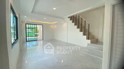 Spacious modern living room with staircase and large windows