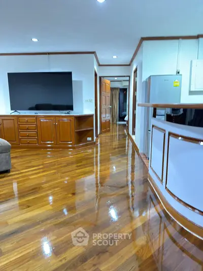 Spacious living room with polished wooden floors and modern entertainment setup