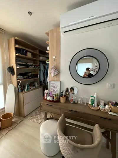 Stylish bedroom with modern vanity and organized closet space, perfect for urban living.