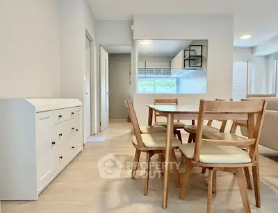 Modern dining area with wooden table and chairs, open layout to kitchen, bright and inviting space.