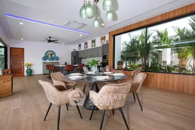 Luxurious open-plan living room with elegant dining area and garden view, featuring modern decor and ample natural light.