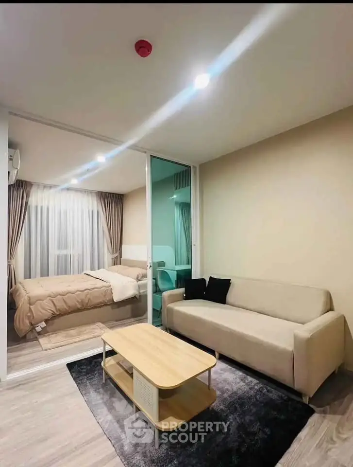 Modern studio apartment with cozy living area and bedroom, featuring elegant decor and natural lighting.