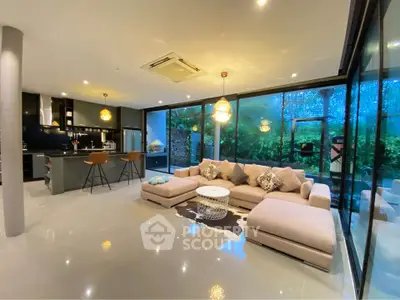 Luxurious open-plan living room with modern kitchen and stunning garden view.