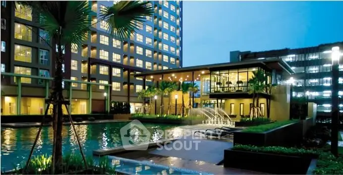 Luxurious apartment complex with stunning pool and modern architecture at dusk.