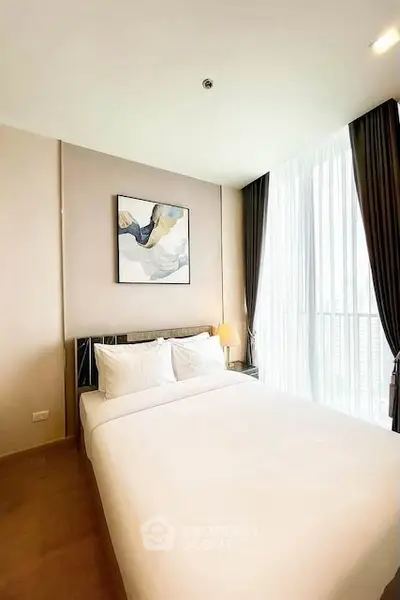 Bright and airy bedroom with modern decor and large window view.