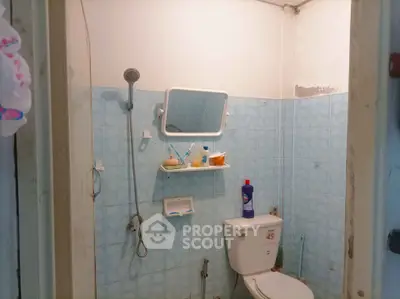 Cozy bathroom with blue tiles and essential fixtures, perfect for a compact living space.
