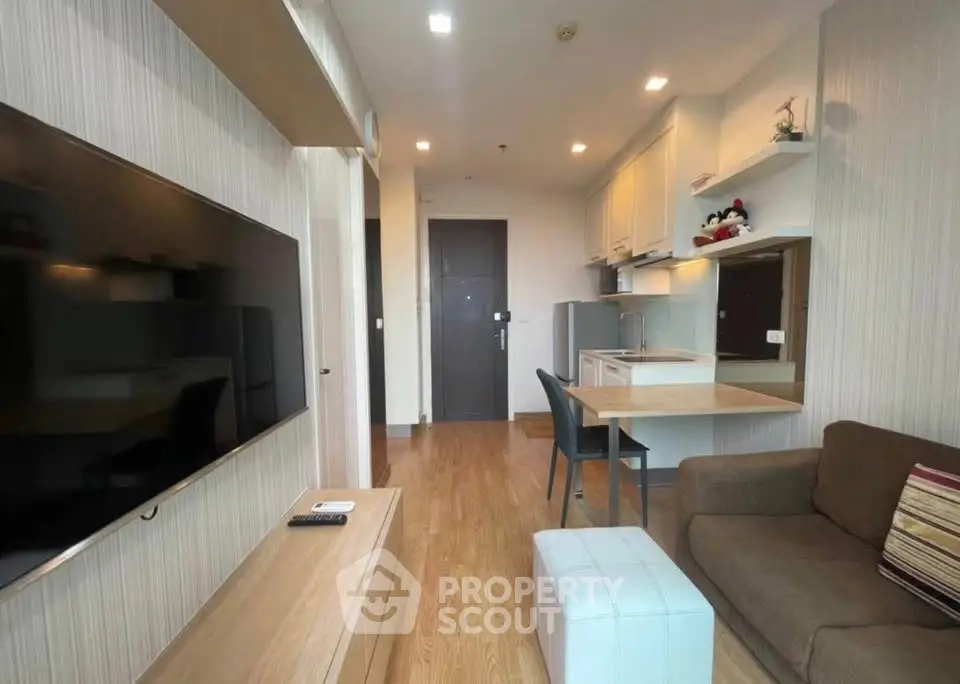 Modern living room with sleek furniture and open kitchen layout, perfect for urban living.