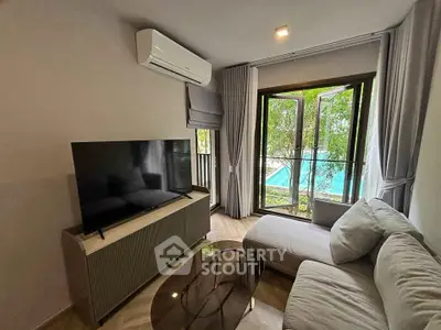 Cozy living room with modern decor and pool view through large window.