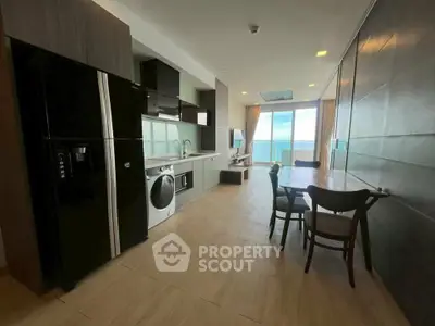 Modern open-plan kitchen and living area with ocean view and sleek appliances.