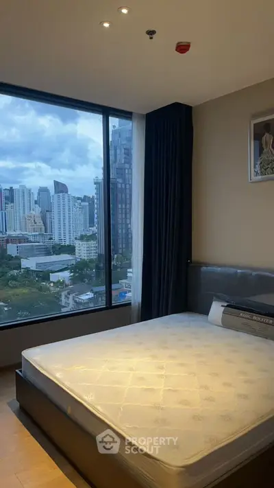 Modern bedroom with large window offering stunning city view