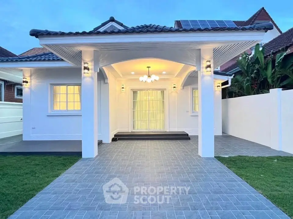 Charming white house with elegant entrance and solar panels, perfect blend of modern and classic design.
