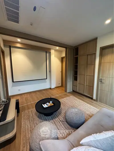 Modern living room with stylish decor and built-in storage, featuring a cozy seating area and projector screen.