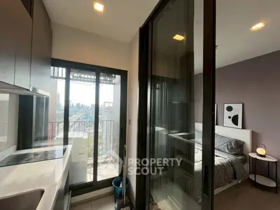 Modern apartment with sleek kitchen and cozy bedroom, featuring a stunning city view from the balcony.