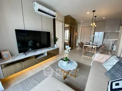 Modern living room with sleek furniture and open kitchen layout in a stylish apartment.