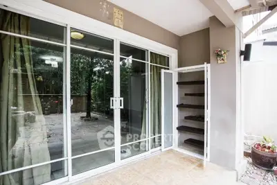 Spacious patio with sliding glass doors and garden view, perfect for relaxation and outdoor gatherings.