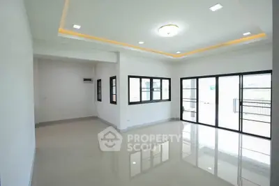 Spacious modern living room with large windows and glossy tiled floors