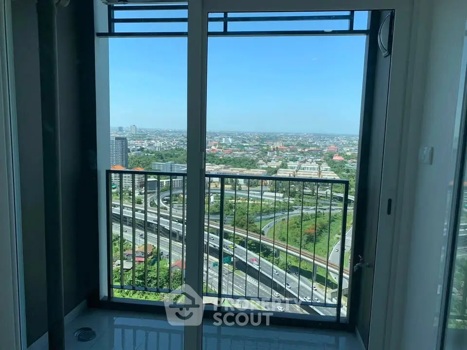 Stunning high-rise apartment view with balcony overlooking cityscape and highways.