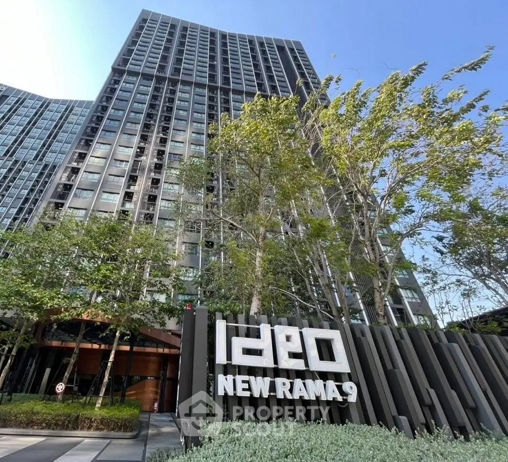 Modern high-rise building with lush greenery at Ideo New Rama 9