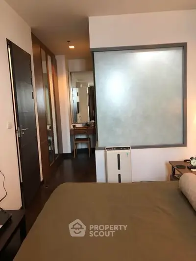 Modern bedroom with stylish decor and ensuite bathroom in a contemporary apartment.