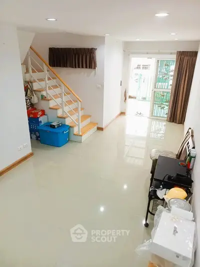 Spacious living room with staircase and natural light in modern home