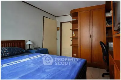 Cozy bedroom with wooden furniture and blue bedding, ideal for restful nights.