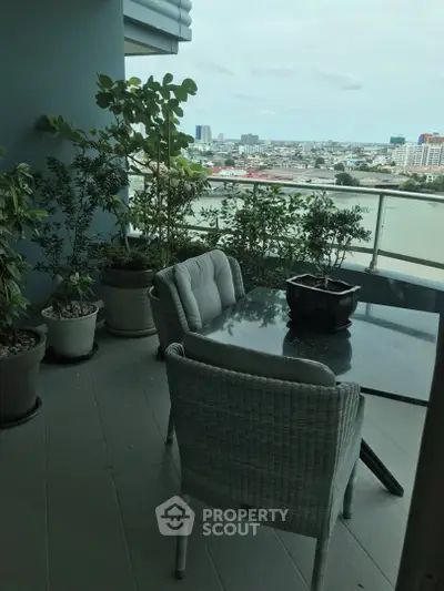 Spacious balcony with city and river view, perfect for relaxation and outdoor dining.