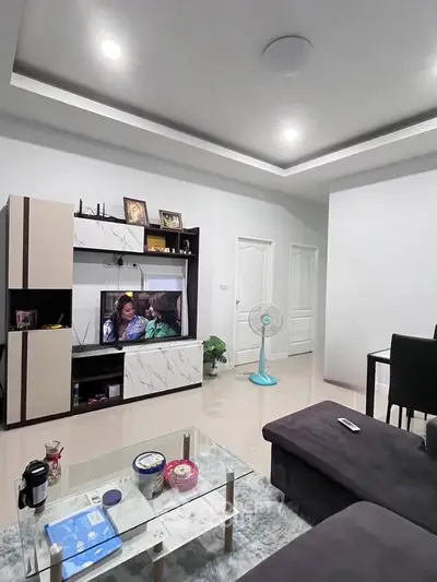 Modern living room with sleek entertainment center and cozy seating area.