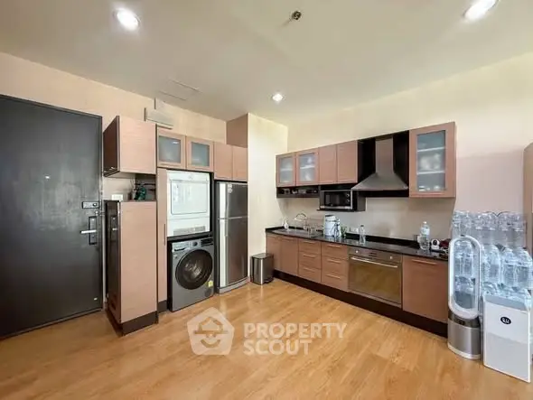 Modern kitchen with sleek cabinetry and stacked washer-dryer unit