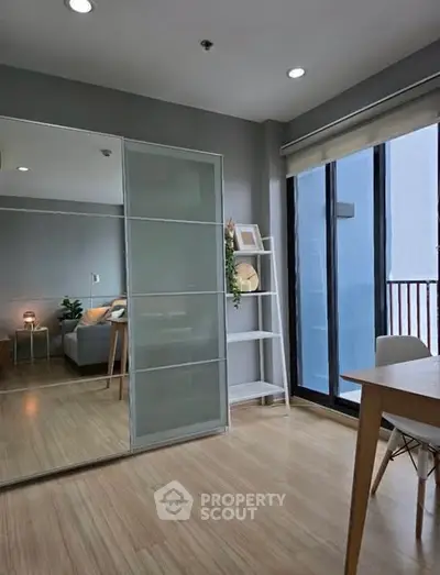 Modern bedroom with sliding mirror closet and balcony access