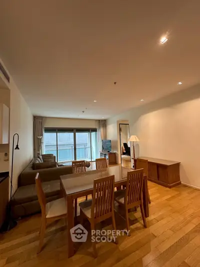 Spacious living room with dining area and modern furniture in a cozy apartment.